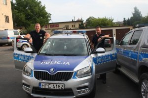 dwóch policjantów stojących przy radiowozie