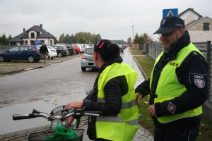 policjant zakłada kamizelkę odblaskową rowerzystce