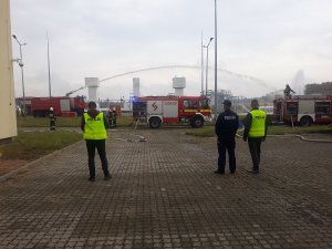 policjanci zabezpieczają miejsce wycieku ropy, strażacy gaszą pożar