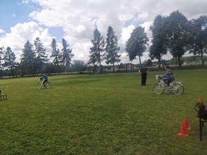 policjant nadzoruje jadących na rowerze dzieci