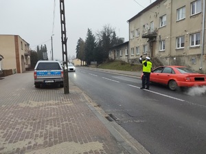 policjant na drodze sprawdza stan trzexwości kierowcy samochodu