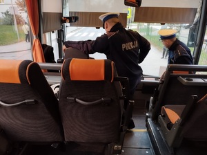 policjanci stoja przy kierowcy w autobusie